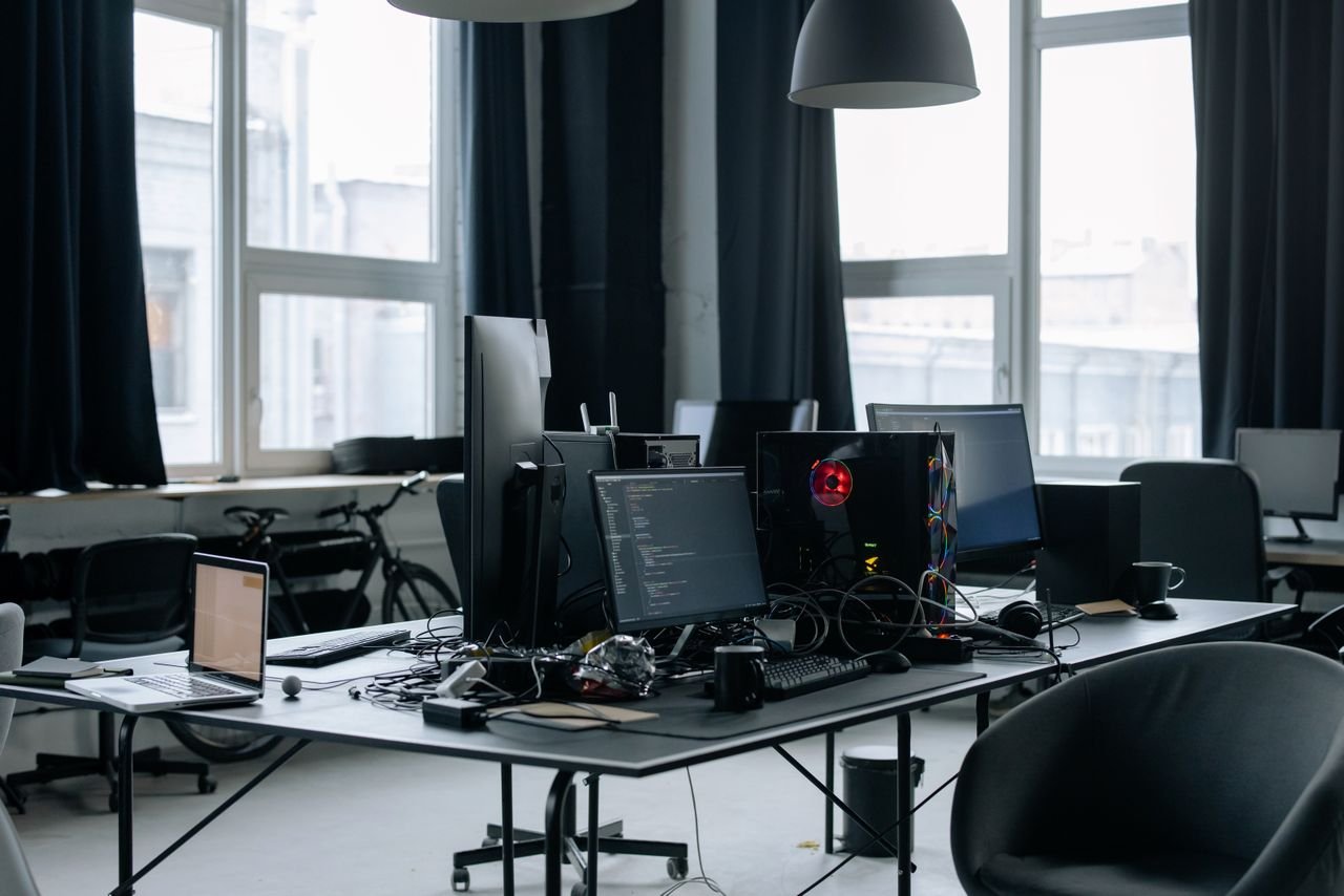 Services Contemporary workspace featuring computers, coding screens, and office essentials in a tech environment.